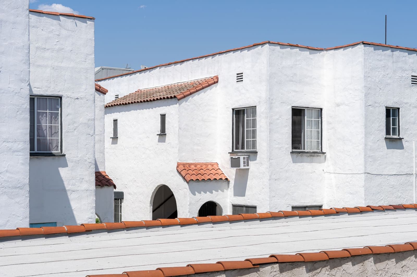 White stucco house with clay tile roof edges