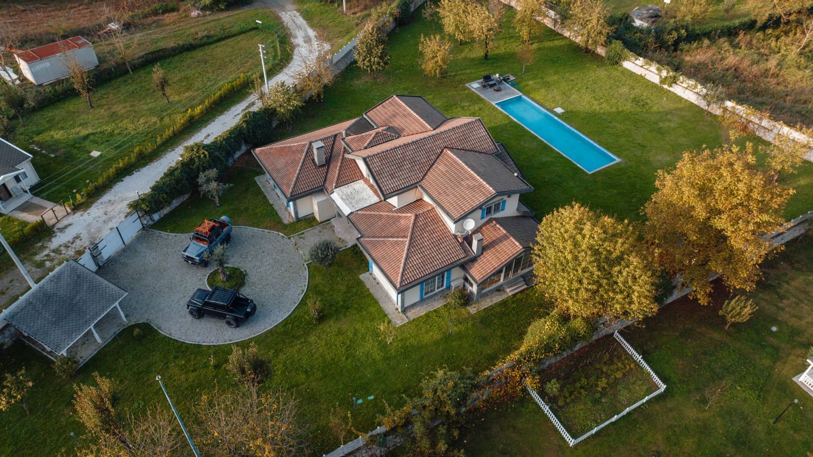 Aerial view of house with tile roof and pool