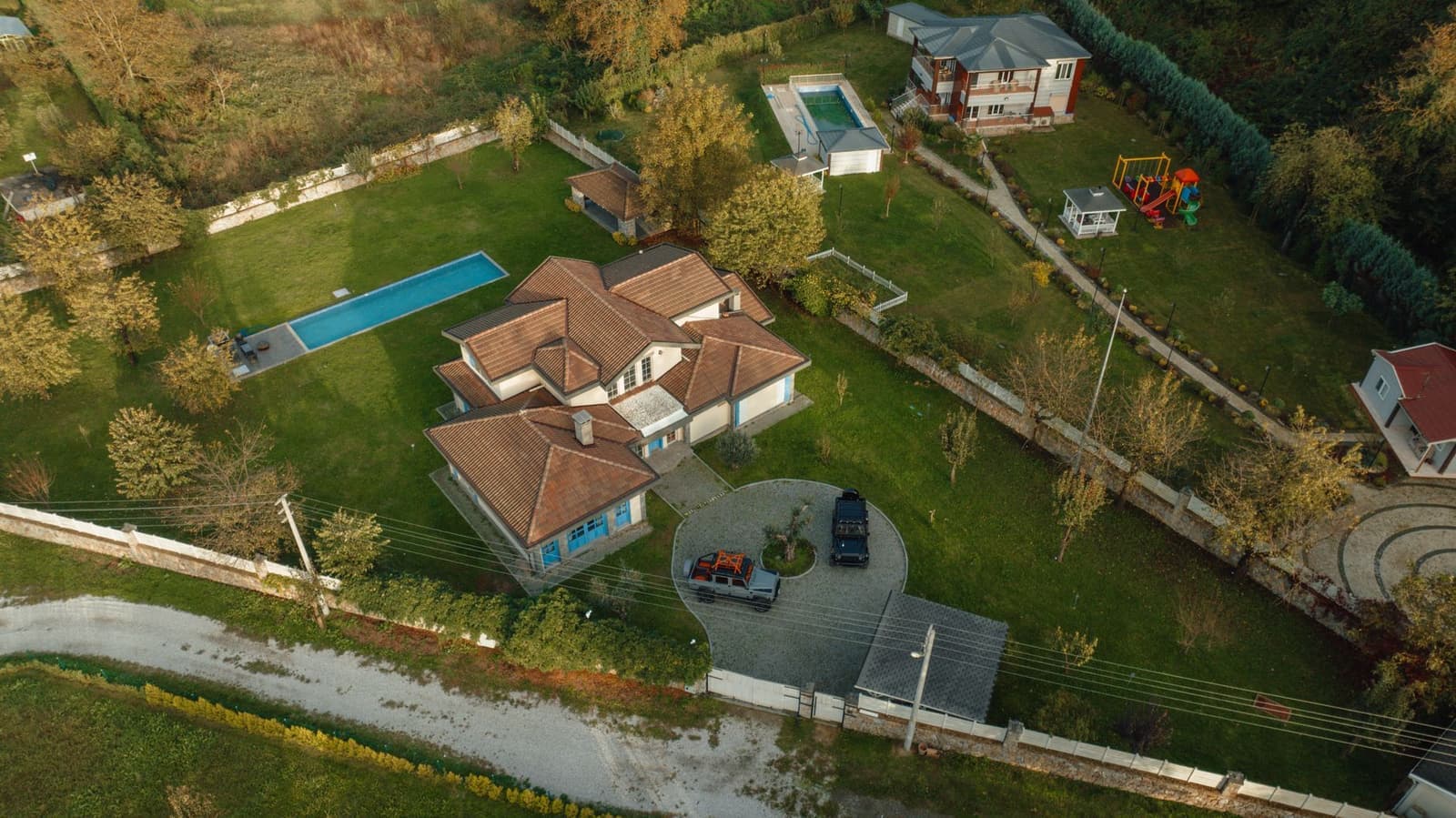 Aerial view of house with tile roofs and pool