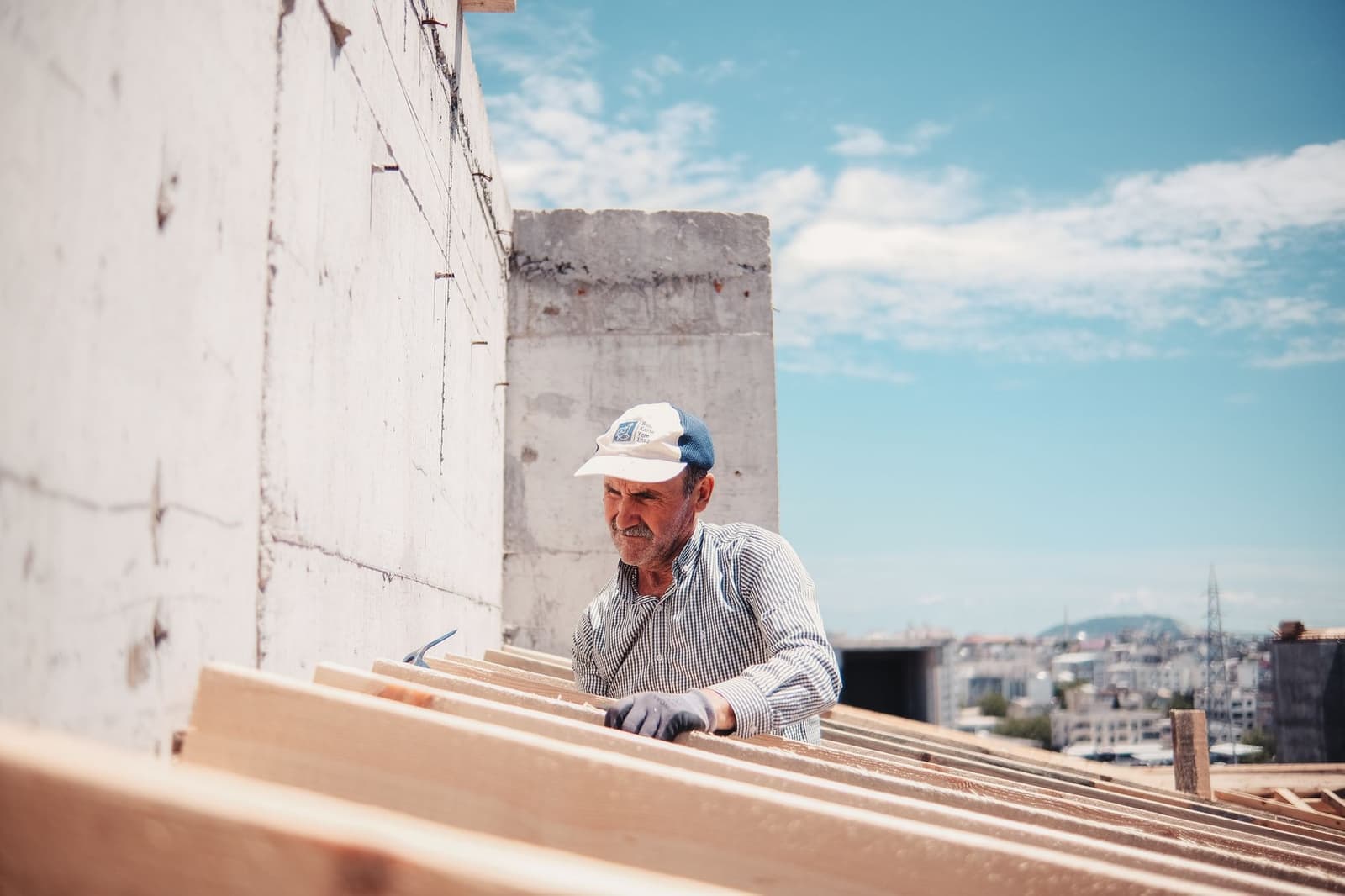 Worker handling roof sheathing boards on a building