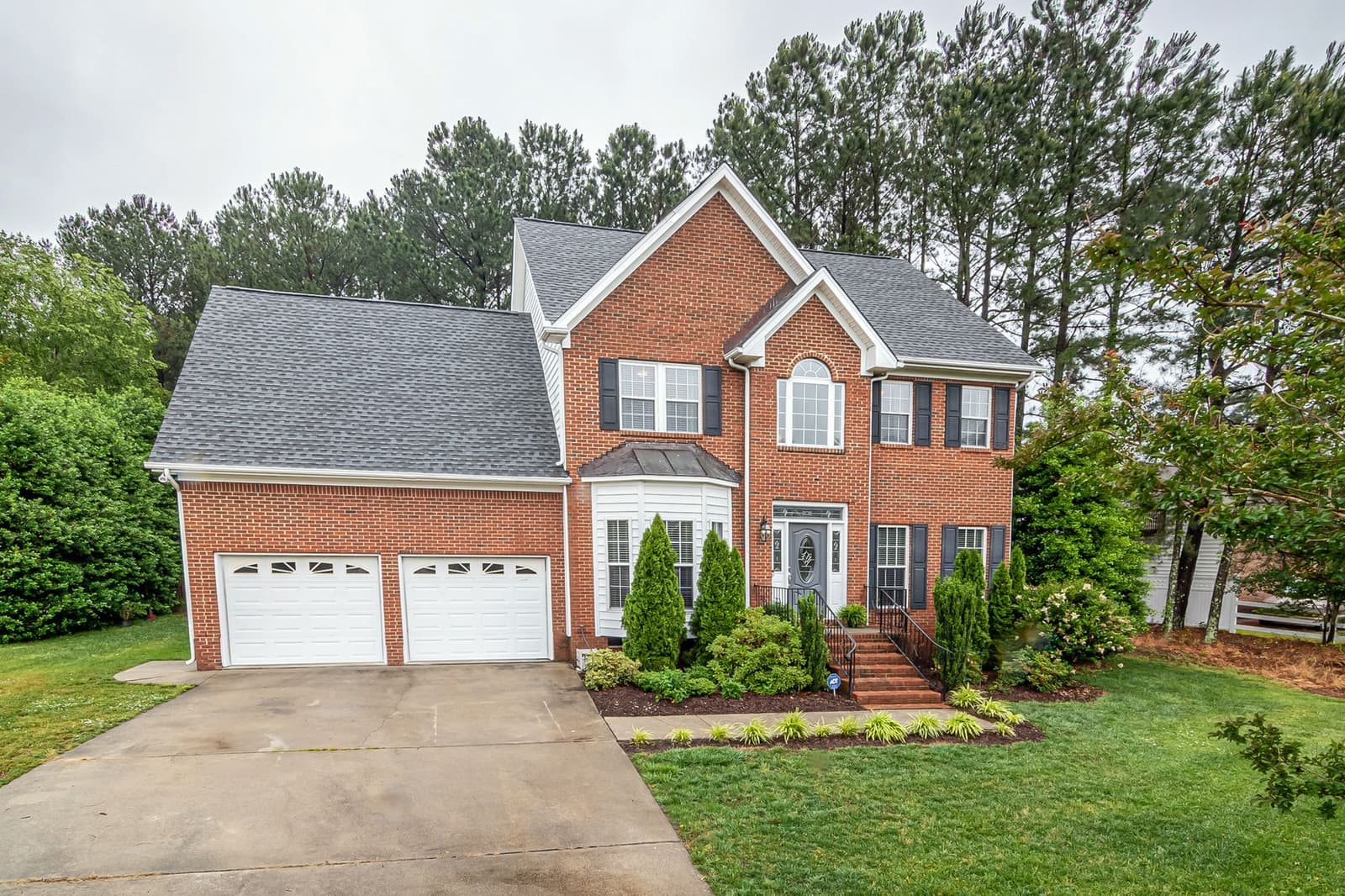 Brick house with gray shingle roof and garage