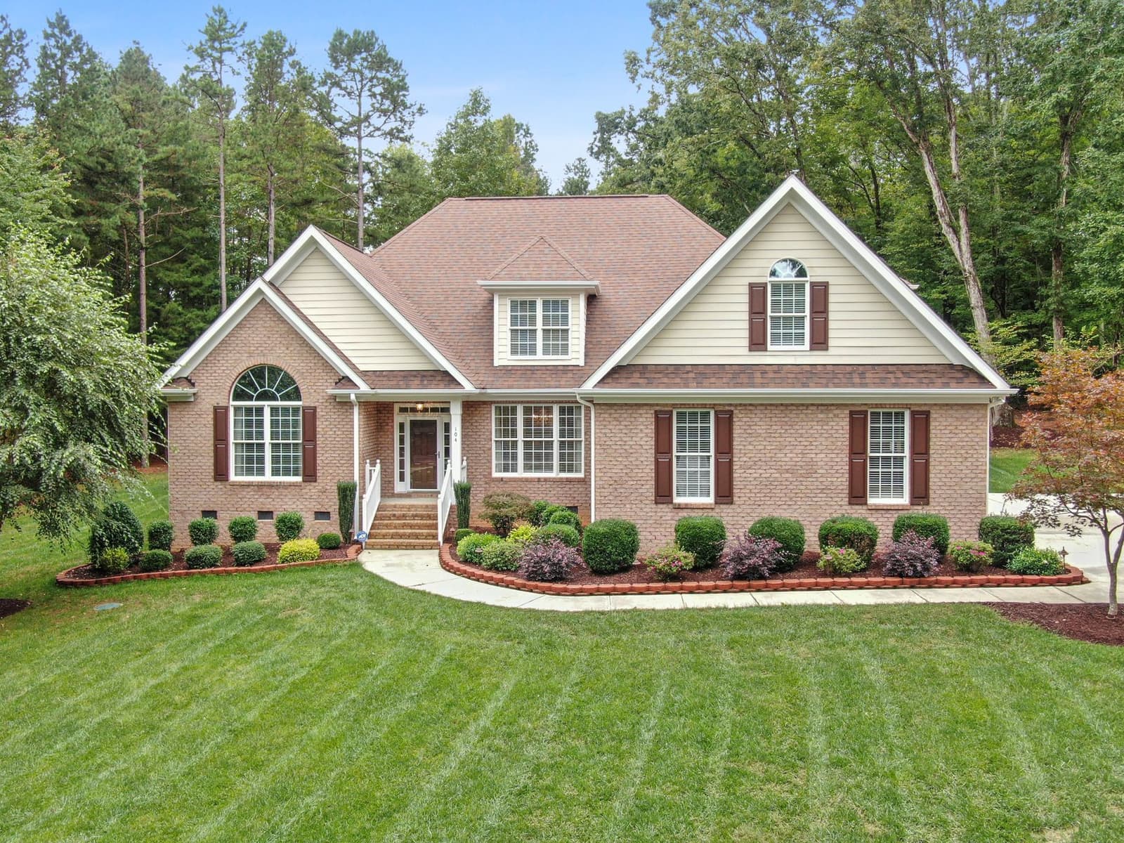 Brick house with shingle roof and lawn