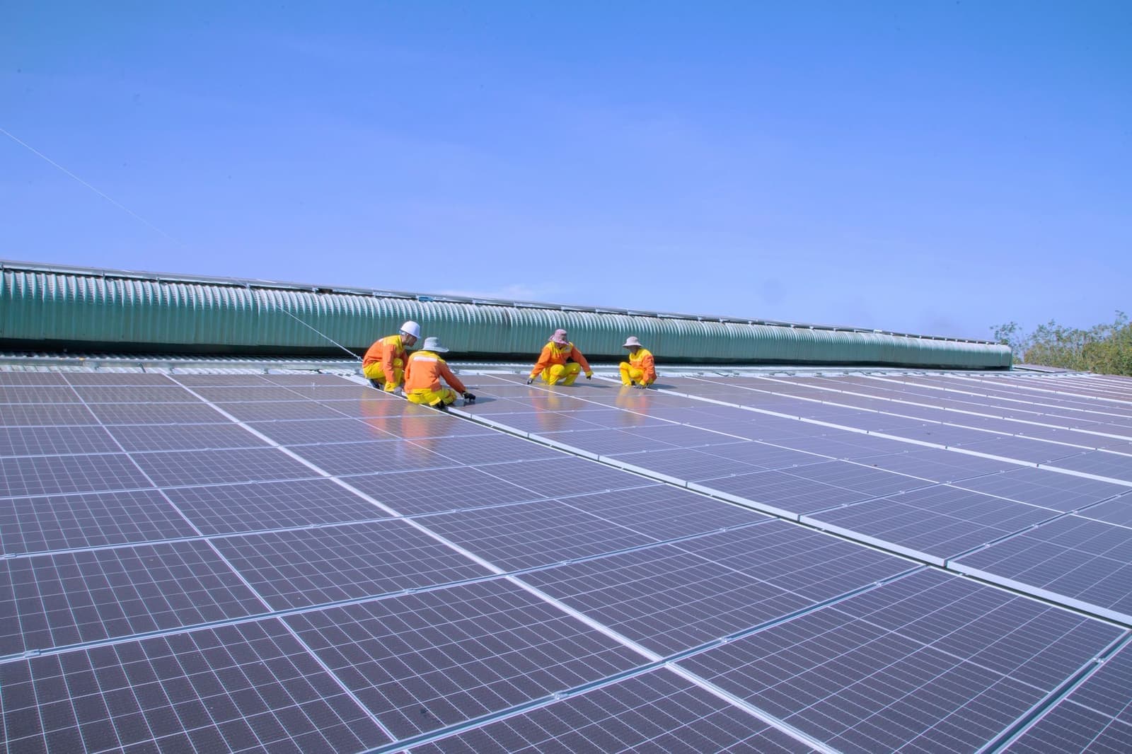 Crew installing solar panels on a commercial roof