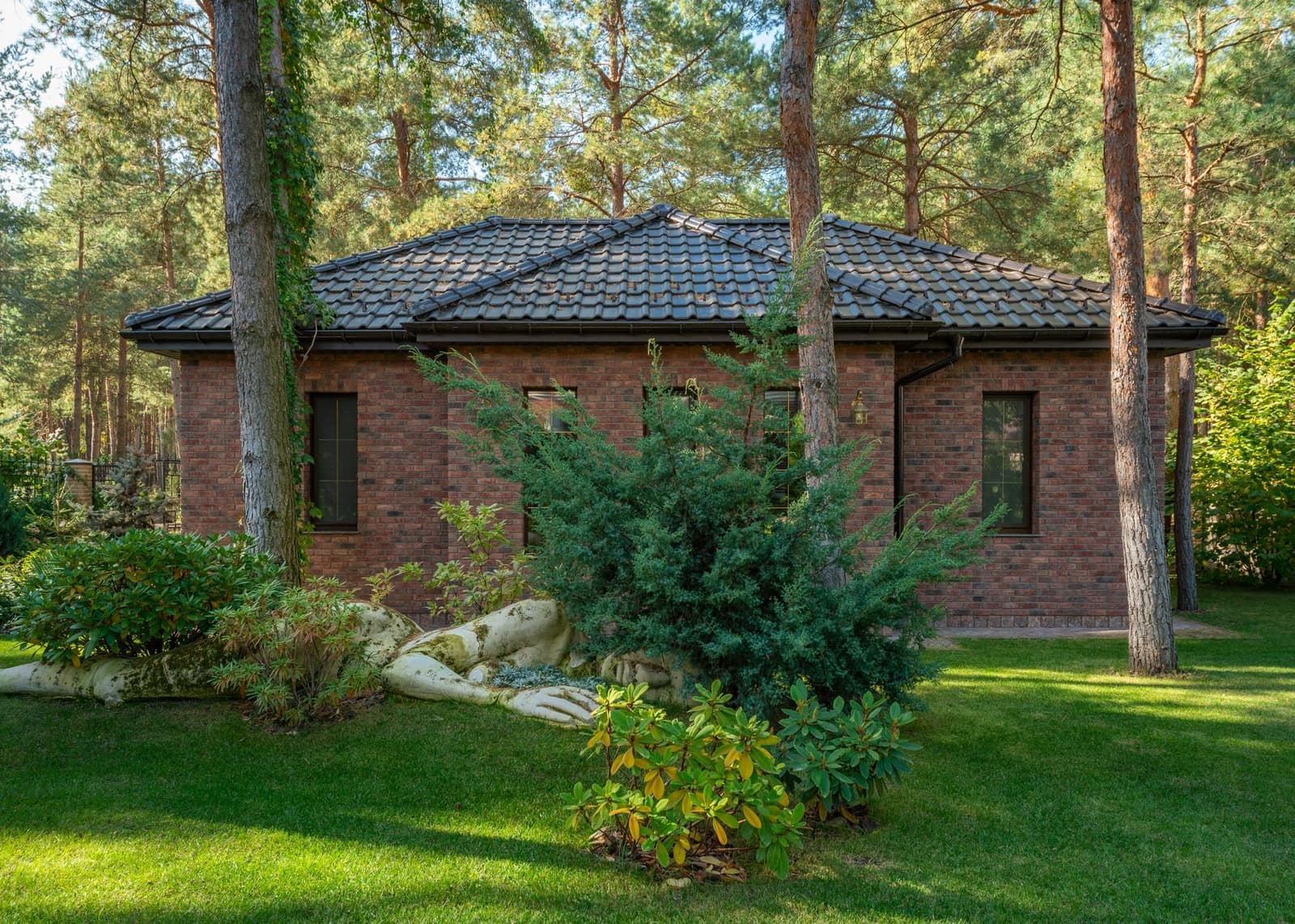Brick house with dark tile roof and garden
