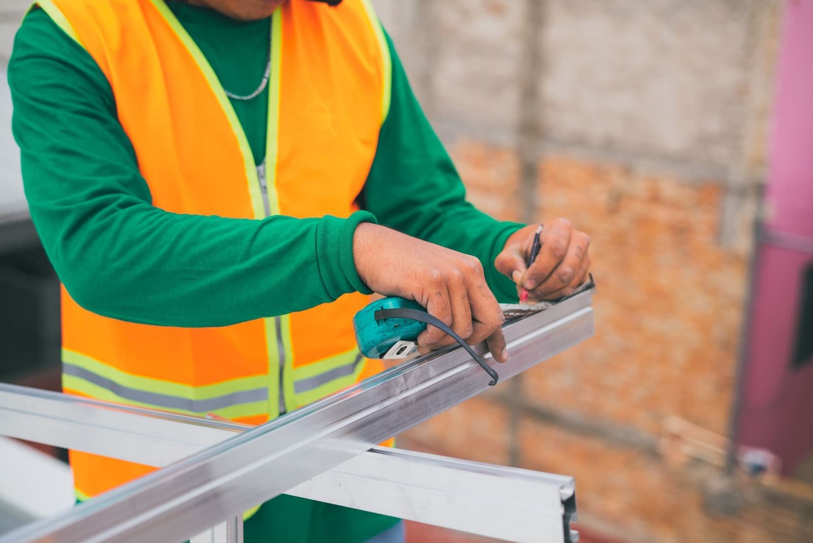 Worker fixing solar mounting rail on a roof