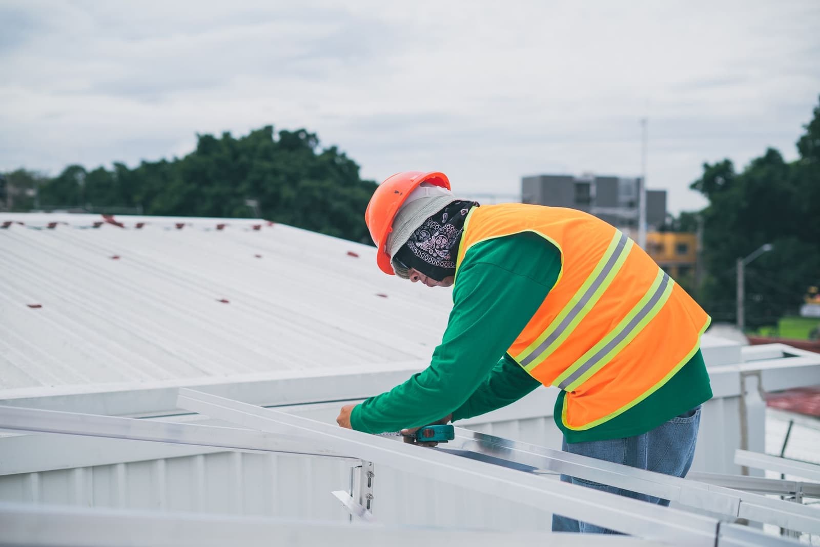 Worker installing solar mounts on a flat roof