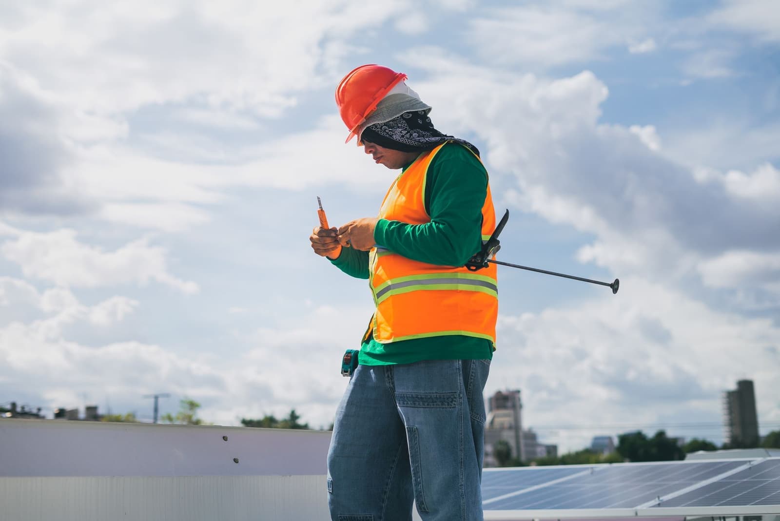Worker with measuring tape on a rooftop