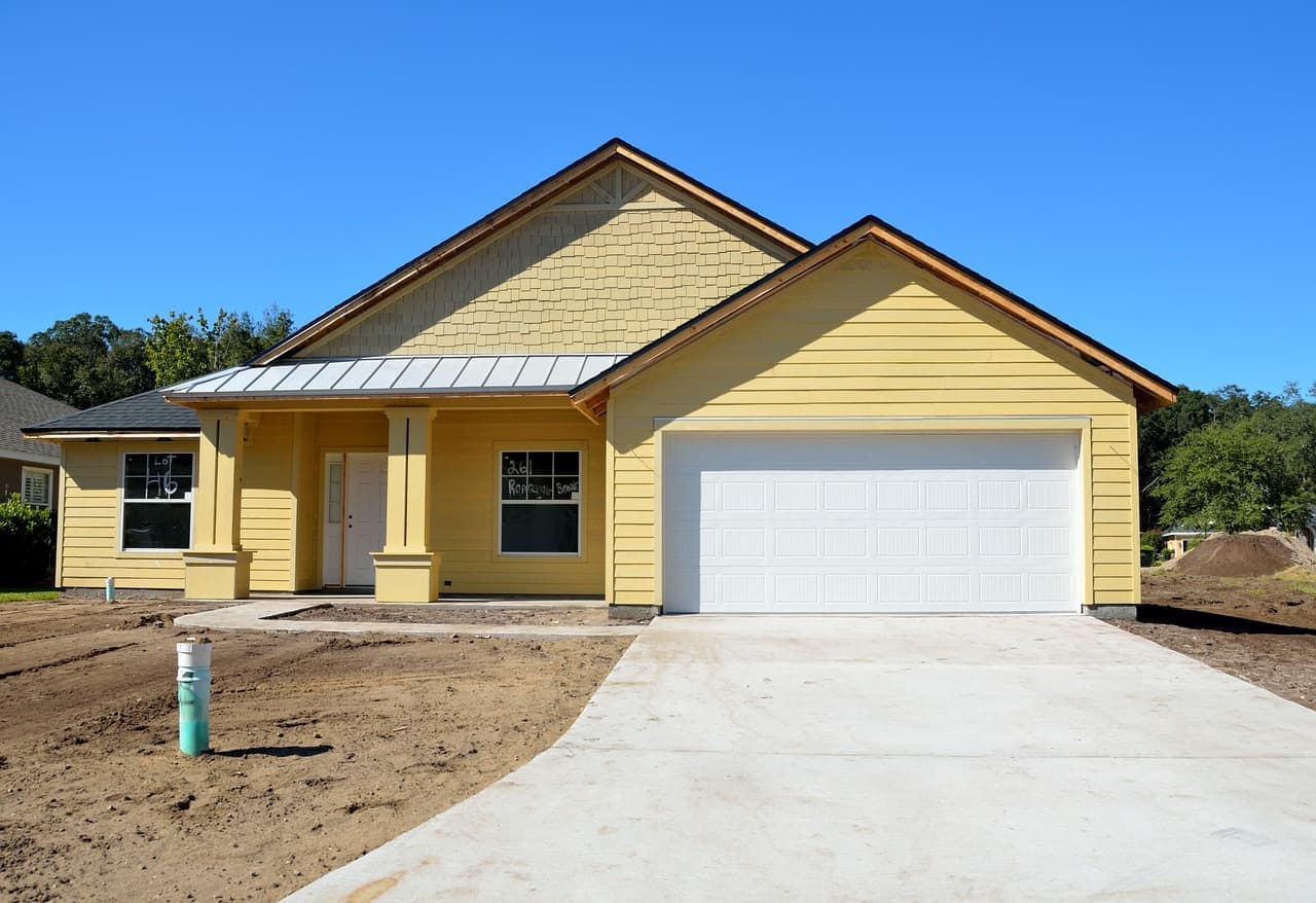 Yellow house with shingle roof and garage