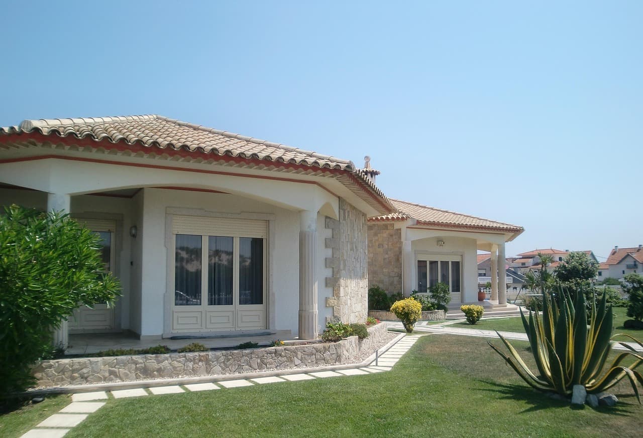 Stucco house with clay tile roof and lawn