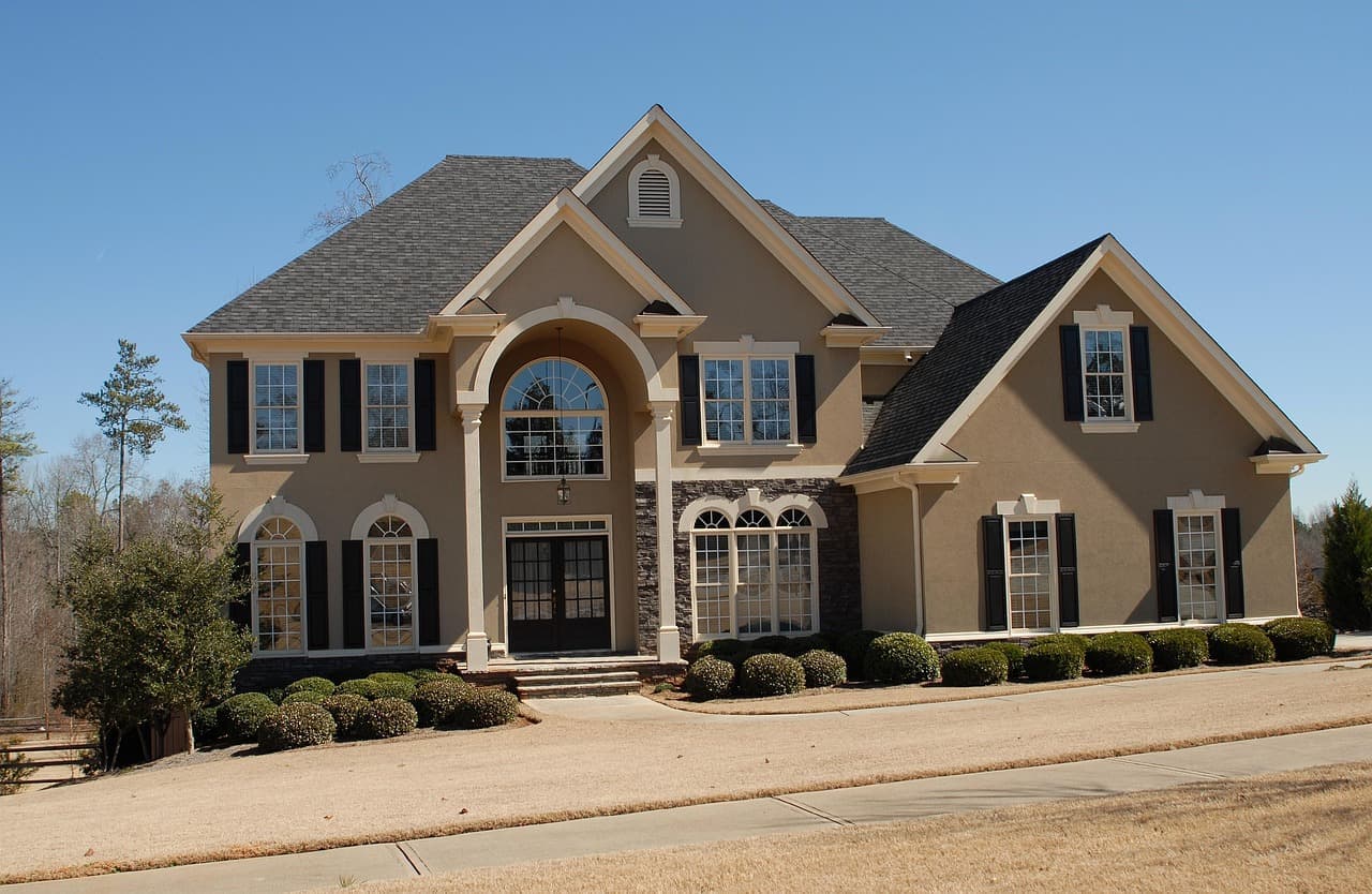 Large stucco house with shingle roof