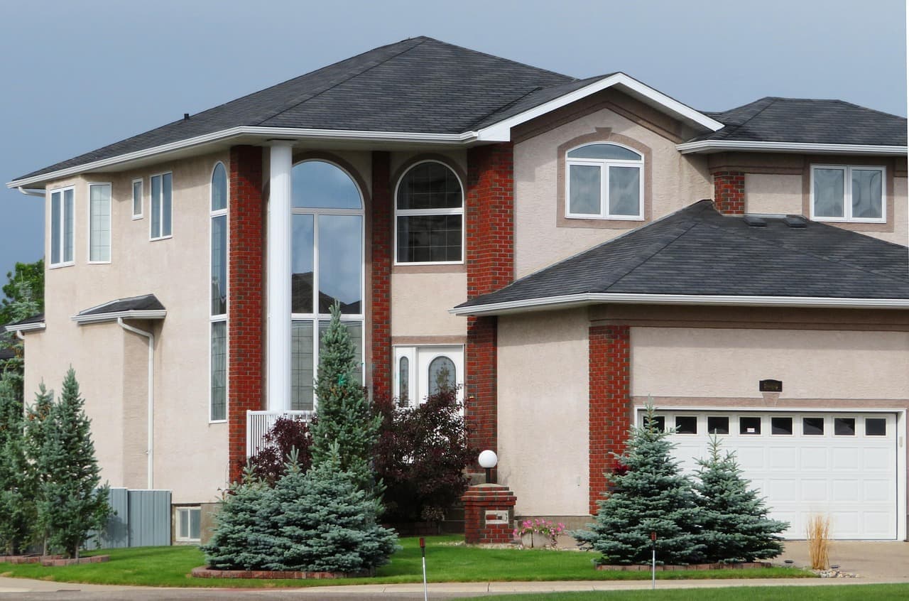 Stucco two-story house with dark shingle roof